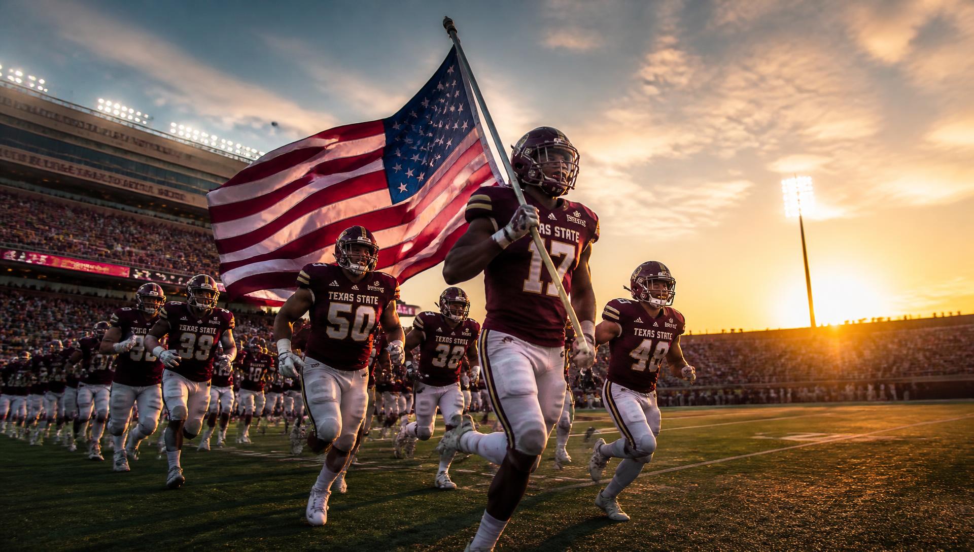 College American football players running onto the field carrying the American flag